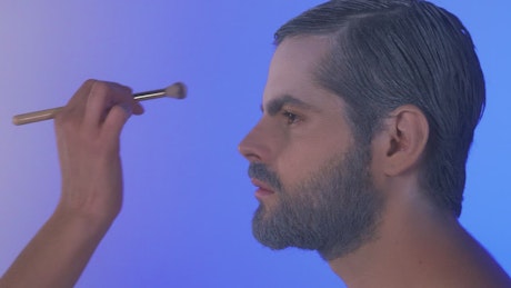 Bearded man being made up