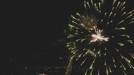 Beautiful, large fireworks exploding high in the night sky.