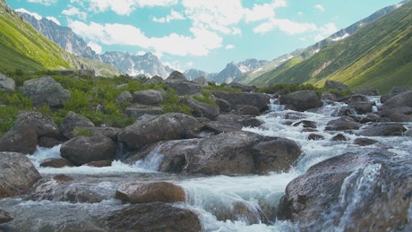 Beautiful river with rocks and mountains in the background.