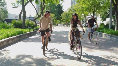 Bike ride of a couple through a city park