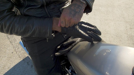 Biker putting on riding gloves.
