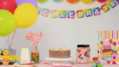 Birthday party table with balloons falling
