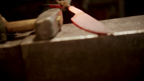 Blacksmith striking a red-hot knife with a mallet