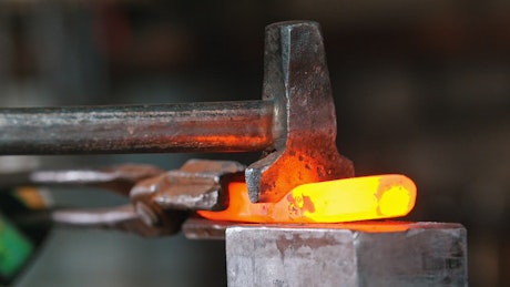 Blacksmith working on a  piece incandescent metal