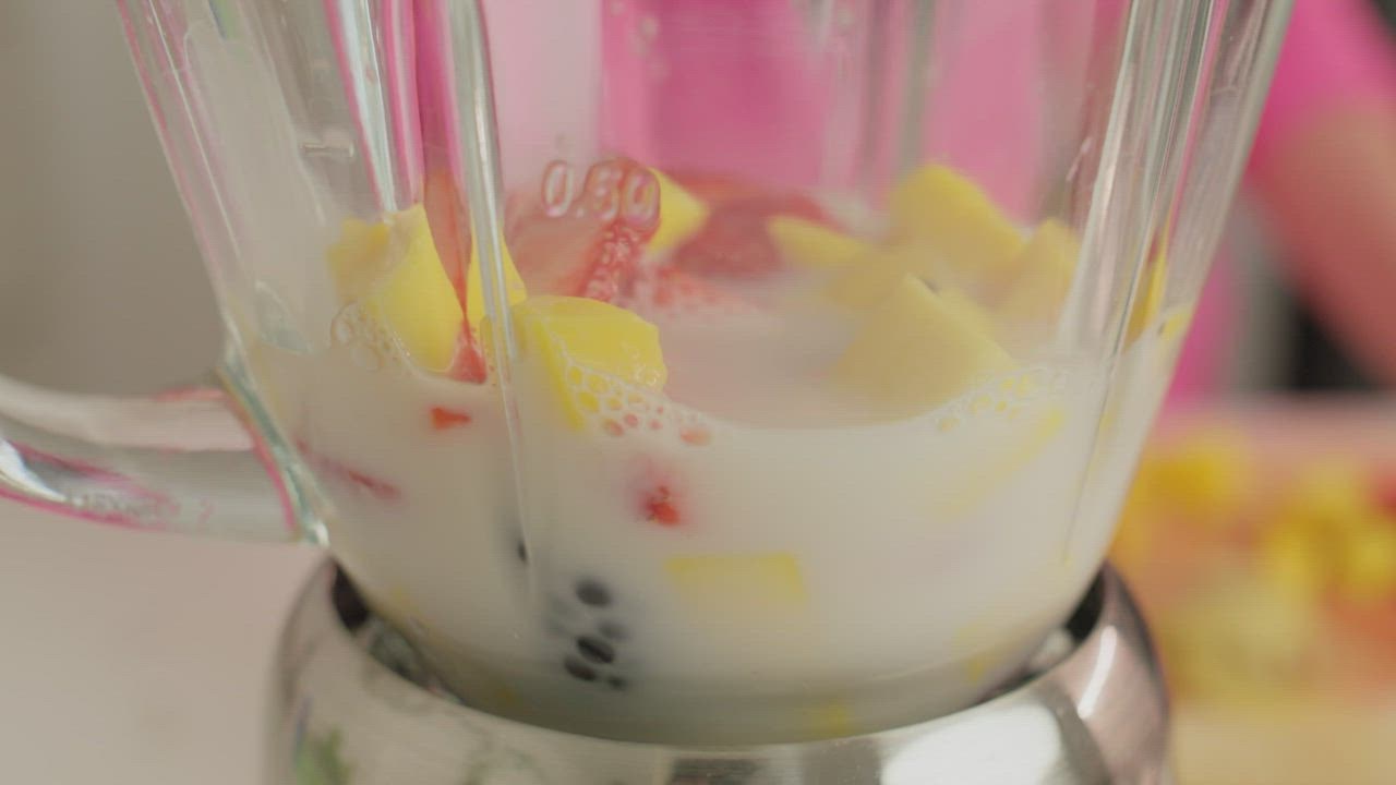 Putting Ice Cubes And Mixed Fruit Along With Pineapple Juice Into Blender  For Fruit Smoothie Free Stock Video Footage Download Clips