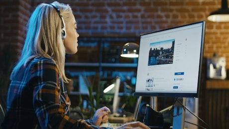 Blonde girl surfing the Internet at the office.