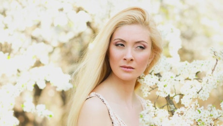Blonde woman among white flowers, portrait