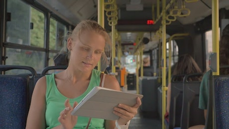 Blonde woman emailing on a bus