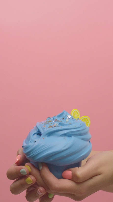 Blue plasticine in the shape of ice cream and silver confetti.
