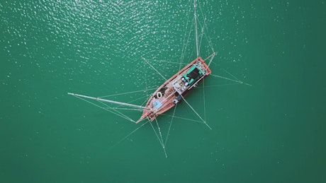 Boat in the middle of the sea seen from top.