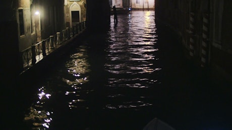 Boat sailing through the night in Venice.