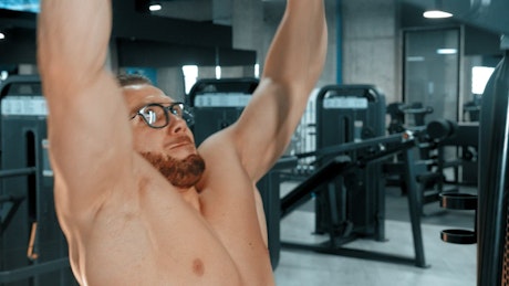 Bodybuilder doing shoulder exercises at the gym.