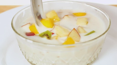 Bowl with yogurt served with chopped fruit.