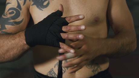 Boxer wrapping their hands in black fabric
