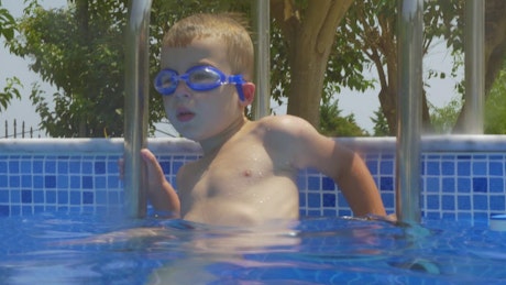 Boy climbing into a pool