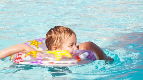 Boy swimming with a plastic ring