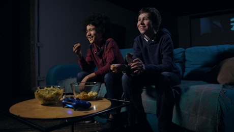 Boys eating popcorn while watching TV