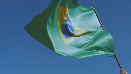 Brazilian flag waving on top of a flagpole.
