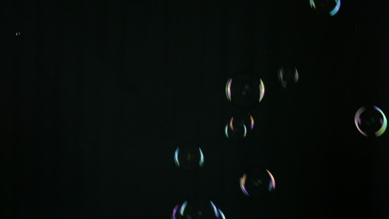 Bubbles falling on a black background - Free Stock Video