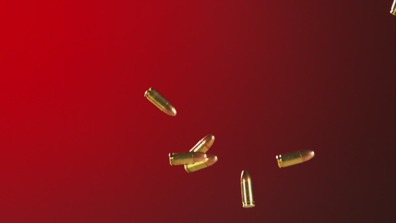 Bullets falling and bouncing in a red background - Free Stock Video