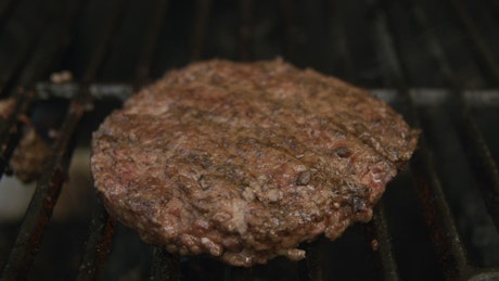 Burgers fired on a grill.