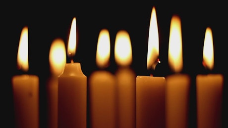 Burning candles in the dark, close up.