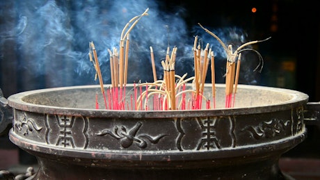Burning incenses inside of a pot.