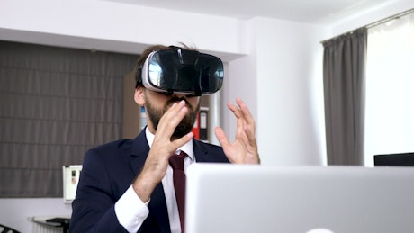 Businesman uses VR headset to visualise data.
