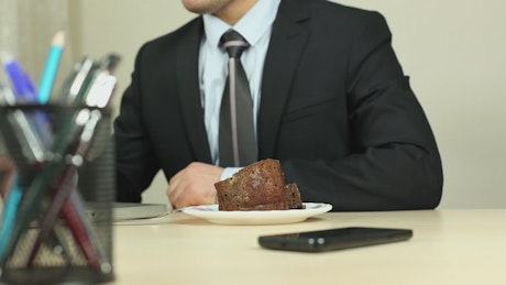 Businessman eating while working at the computer.