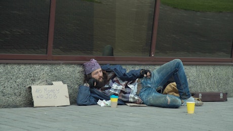 Businessman giving money to homeless man.