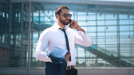 Businessman on mobile phone in Dubai street.