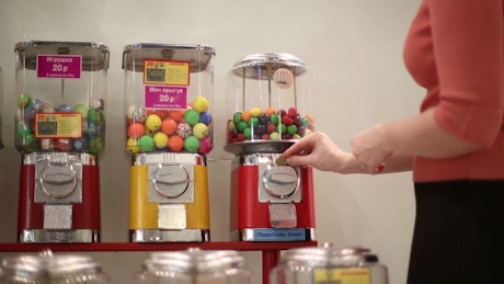 Buying gumball candy from a vending machine.
