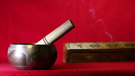 Calming Indian singing bowl on a red background.