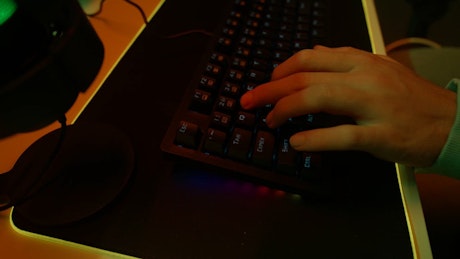 Camera hovers over a hand on a backlit keyboard.