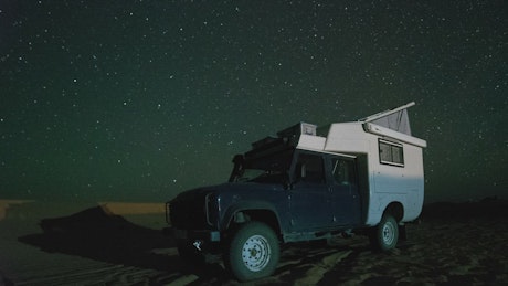 Camper van in the Sahara desert at night.