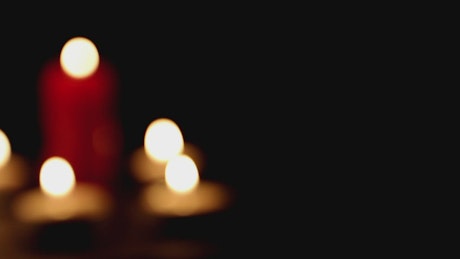 Candles burning in the dark, out of focus shot