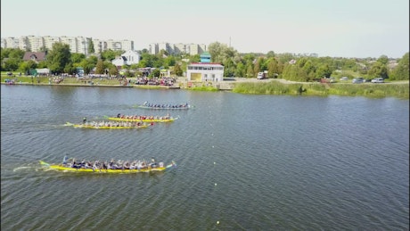 Canoe rowing competition in river reaching the finish line.