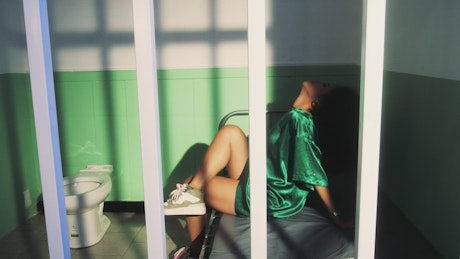 Captivating woman in a jail cell after a party.