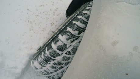 Car wheel turning in the snow, top view.