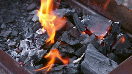 Carbon chunks and flames burning in the brazier.