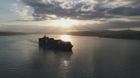 Cargo ship sailing at dusk.