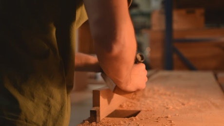 Carpenter sanding a wood in his workshop.