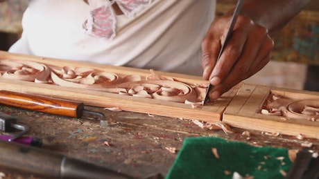 Carving a design into wood.
