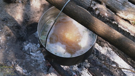Casserole with boiling water on a campfire