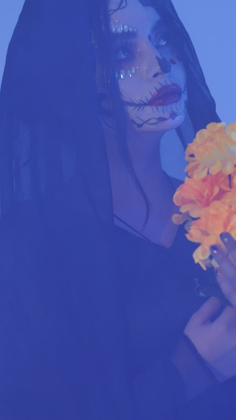 Catrina girl with a bouquet of marigold flowers.