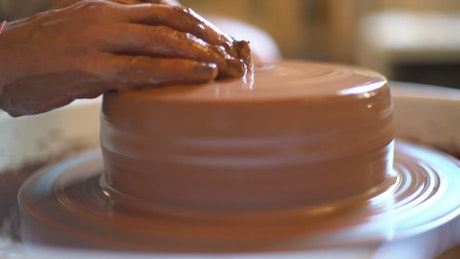 Ceramic artist hands working on the potter wheel