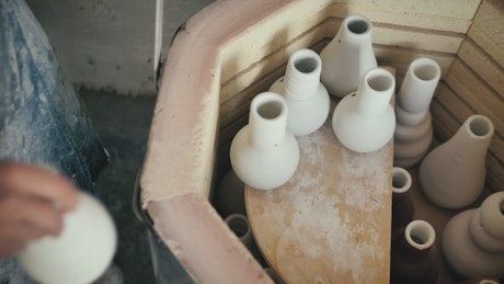 Ceramic artist preparing an oven.