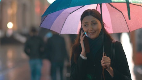 Chatting on the phone under an umbrella