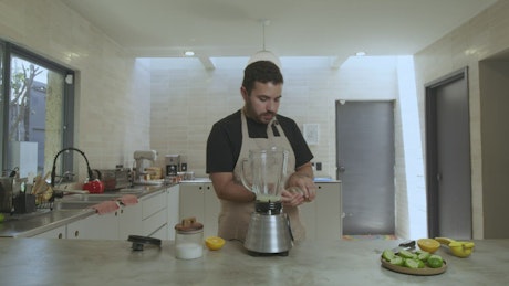 Chef adding ingredients to a blender.