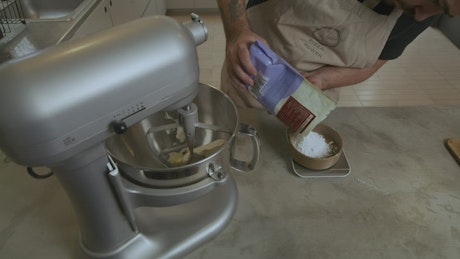 Chef adding ingredients to an electric mixer